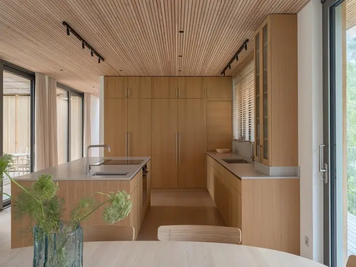 Cocina moderna de madera con luz natural en Yngsjö House.