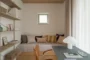 Dormitorio pequeño con escritorio y estanterías de madera.