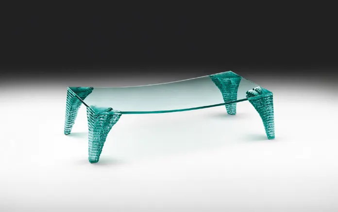 Mesa de centro de vidrio con tablero curvado y patas esculpidas en cristal.